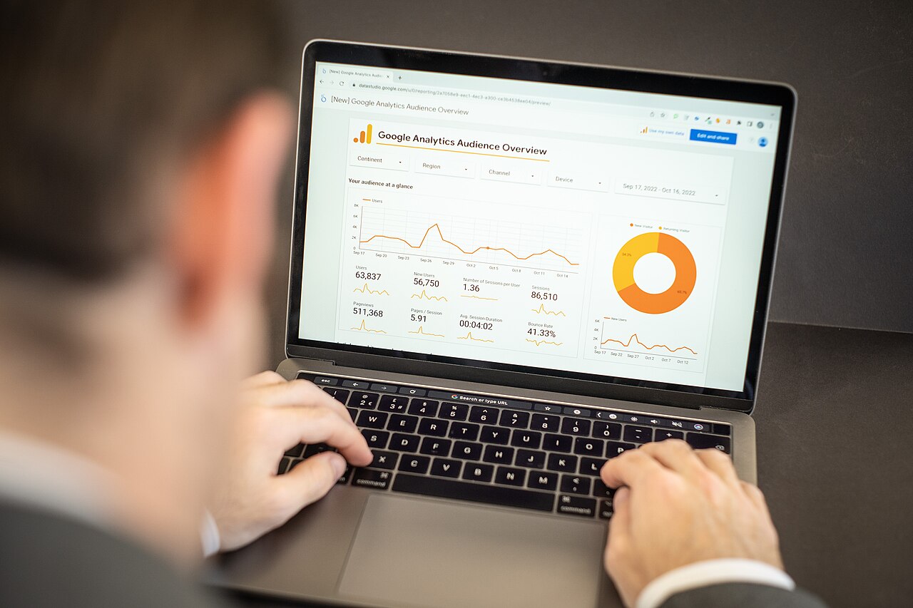 Profissional consulta gráficos e indicadores em um notebook.